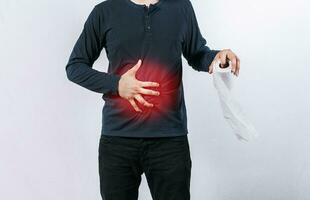 Man with stomach problems holding toilet paper, Person with toilet paper with stomach problems on isolated background, Concept of a person with digestive and diarrhea problems photo