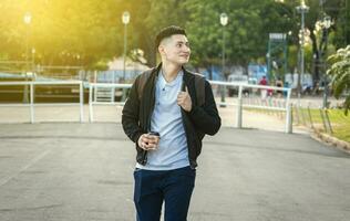 Smiling guy walking down the street, urban handsome guy walking down the street photo