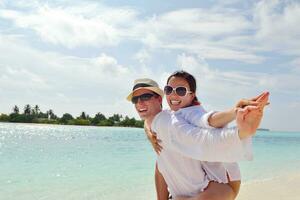 happy young couple have fun on beach photo