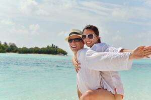 feliz pareja joven divertirse en la playa foto