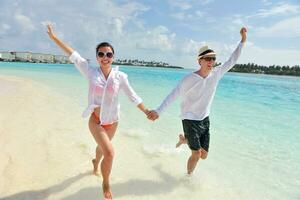 feliz pareja joven divertirse en la playa foto