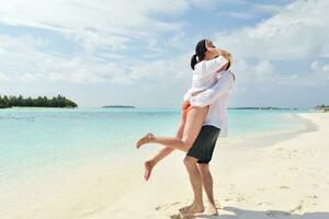 happy young couple have fun on beach photo