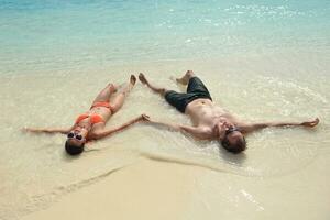 feliz pareja joven divertirse en la playa foto