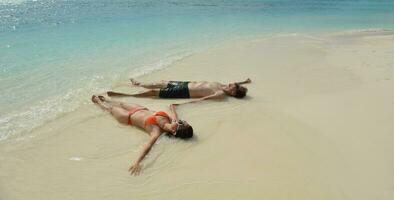 feliz pareja joven divertirse en la playa foto