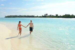 happy young couple have fun on beach photo