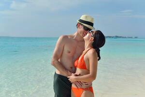 feliz pareja joven divertirse en la playa foto