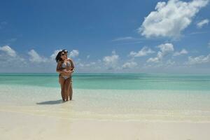 feliz pareja joven divertirse en la playa foto