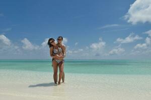 feliz pareja joven divertirse en la playa foto