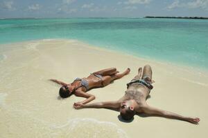 feliz pareja joven divertirse en la playa foto