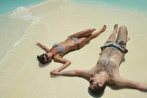 feliz pareja joven divertirse en la playa foto