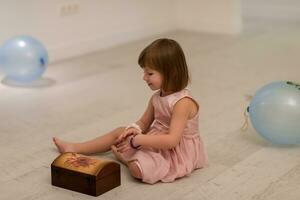 niña disfrutando mientras juega con las joyas de la madre foto