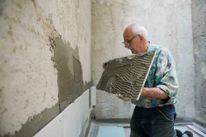 worker installing big ceramic tiles photo