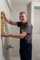 professional plumber using bubble level in a bathroom photo