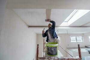 construction worker plastering on gypsum ceiling photo