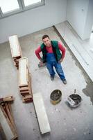 worker installing the ceramic wood effect tiles on the floor photo