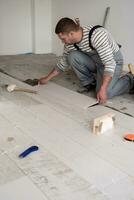 worker installing the ceramic wood effect tiles on the floor photo