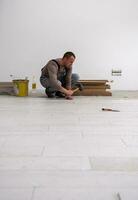 worker installing the ceramic wood effect tiles on the floor photo