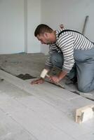 worker installing the ceramic wood effect tiles on the floor photo