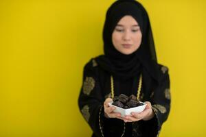 moderno musulmán mujer participación un plato lleno de dulce fechas en iftar hora en Ramadán kareem islámico sano comida concepto OVNI verde antecedentes foto