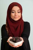 moderno musulmán mujer participación un plato lleno de dulce fechas en iftar hora en Ramadán kareem islámico sano comida concepto foto