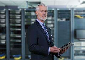 Senior businessman in network server room photo