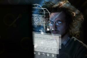 man working on computer in dark office photo