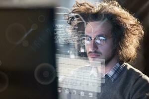 hombre trabajando en una computadora en una oficina oscura foto