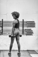 mujer negra haciendo flexiones de bíceps foto