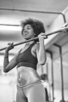 black woman lifting empty bar photo