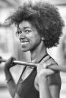 black woman lifting empty bar photo