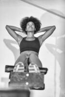 black woman doing sit ups at the gym photo