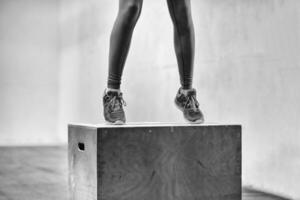 mujer negra está realizando saltos de caja en el gimnasio foto