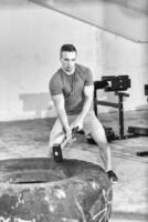 entrenamiento de hombre con martillo y neumático de tractor foto