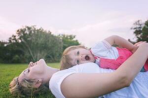 mother and little daughter playing at backyard photo