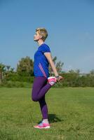 female runner warming up and stretching photo