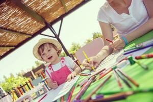 mamá y su pequeña hija dibujando imágenes coloridas foto