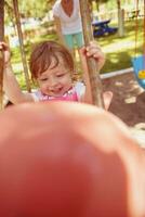 mother and daughter swinging in the park photo