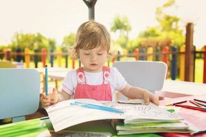 little girl drawing a colorful pictures photo