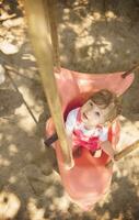 little girl swinging  on a playground photo