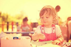 little girl drawing a colorful pictures photo