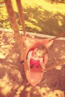 little girl swinging  on a playground photo