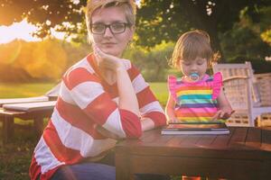 mom and her little daughter using tablet computer photo
