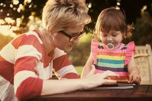 mom and her little daughter using tablet computer photo