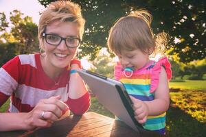 mom and her little daughter using tablet computer photo