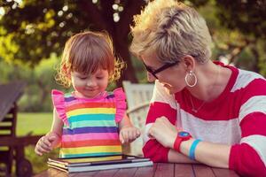 mom and her little daughter using tablet computer photo