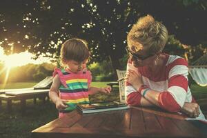 mom and her little daughter using tablet computer photo
