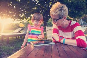 mom and her little daughter using tablet computer photo