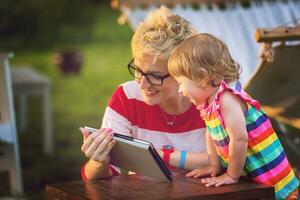 mom and her little daughter using tablet computer photo