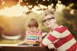 mom and her little daughter using tablet computer photo