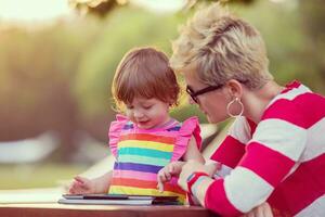 mom and her little daughter using tablet computer photo